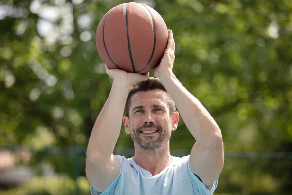 ハンサムな男性は屋外でバスケットボールをして — ストック写真
