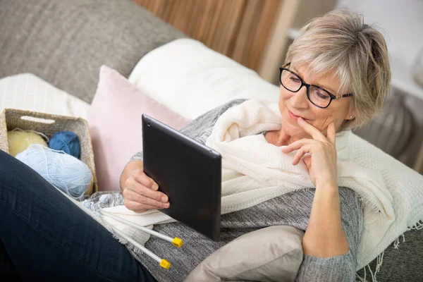 Mulher Sentada Sofá Com Tricô Olhando Para Tela Tablet — Fotografia de Stock