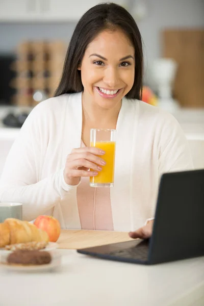 女性はコンピュータで朝食を食べ — ストック写真