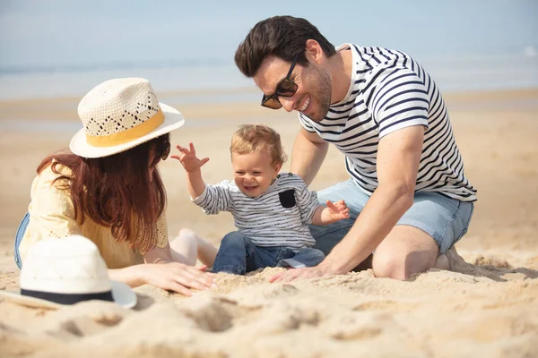 和他们刚出生的儿子在一个安静的海滩上 — 图库照片