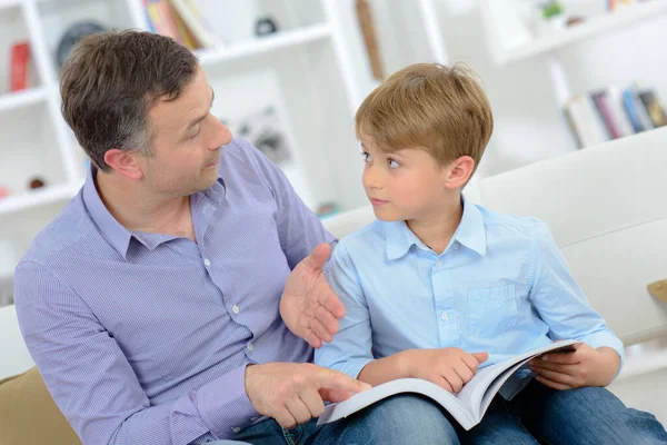 父亲和儿子在看书 — 图库照片