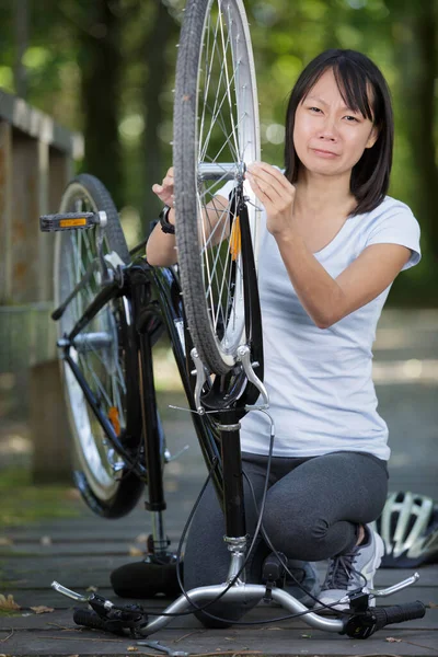 Mulher Está Consertando Bicicleta Elétrica Livre — Fotografia de Stock