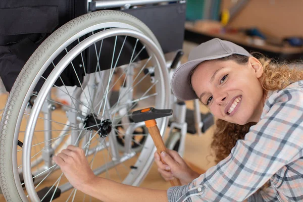 Frau Repariert Rollstuhl Mit Hammer — Stockfoto