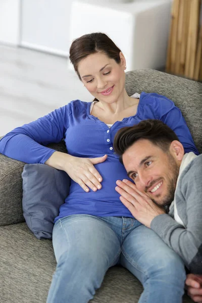 快乐的男人听着孕妇的肚子 — 图库照片