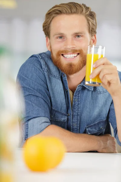 一个微笑着举着一杯果汁的男人 — 图库照片
