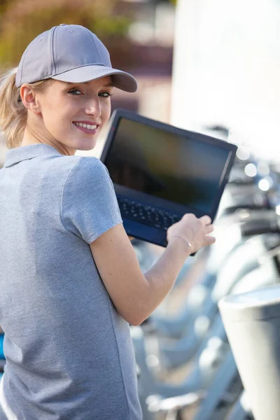 Lycklig Kvinna Använder Laptop Bredvid Cyklar — Stockfoto