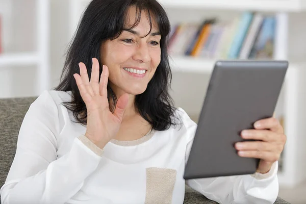 현대의 여성은 태블릿을 사용하여 집에서 소파에 — 스톡 사진