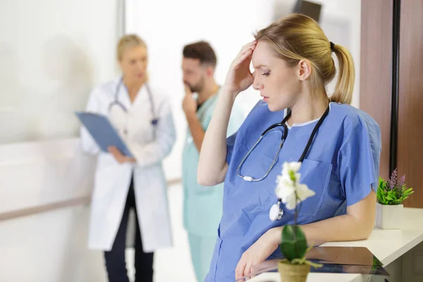 Gestresste Krankenschwester Lehnt Mit Kopfschmerzen Rezeption — Stockfoto