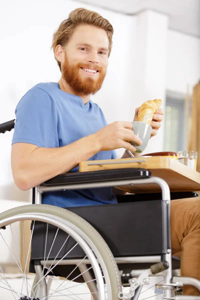 Mężczyzna Wózku Inwalidzkim Jest Gotowy Jedzenia Domu — Zdjęcie stockowe