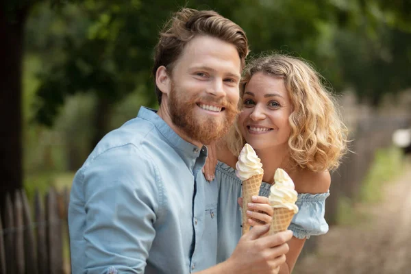情侣们坐在城市的长椅上吃冰淇淋 — 图库照片