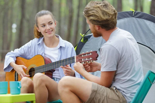 キャンプでギターを楽しんでいる若いカップルの観光客は — ストック写真