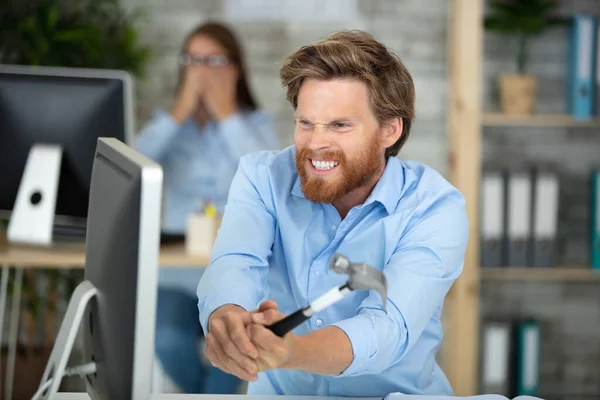 怒っているビジネスマンはハンマーでコンピュータ画面を粉砕 — ストック写真