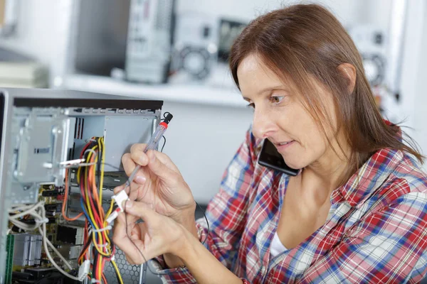 Frau Telefon Repariert Einen Computer Bei Der Arbeit — Stockfoto