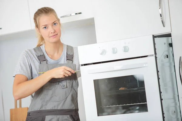 安装烤箱的女工程师 — 图库照片