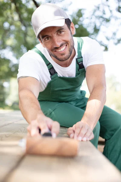 Glücklicher Mann Malt Mit Weißer Farbe Auf Holzplanken — Stockfoto