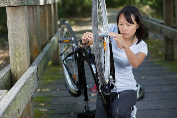 Γυναίκα Φτιάχνει Ηλεκτρικό Ποδήλατο Στο Πάρκο — Φωτογραφία Αρχείου