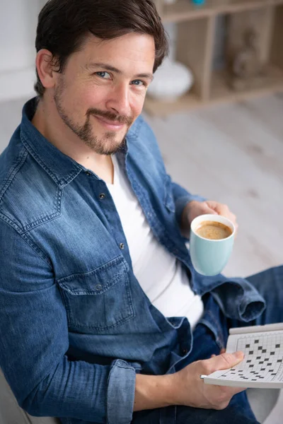 Счастливый Человек Пьет Кофе Кроссворды — стоковое фото