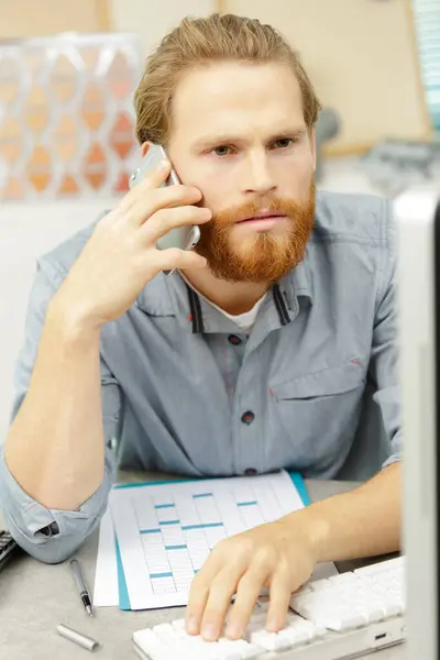 Confus Jeune Homme Parler Téléphone Dans Bureau — Photo