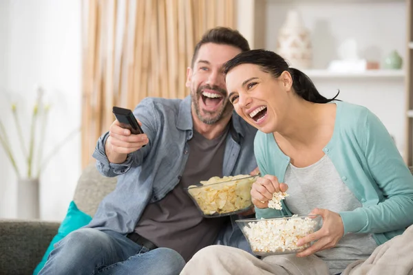 Ευτυχισμένο Ζευγάρι Σνακ Βλέποντας Τηλεόραση Στον Καναπέ Στο Σπίτι — Φωτογραφία Αρχείου