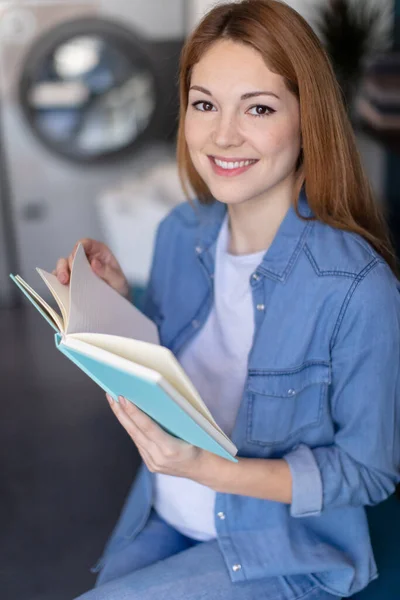 Beautiful Young Woman Reading Book Laundromat — Stock Photo, Image
