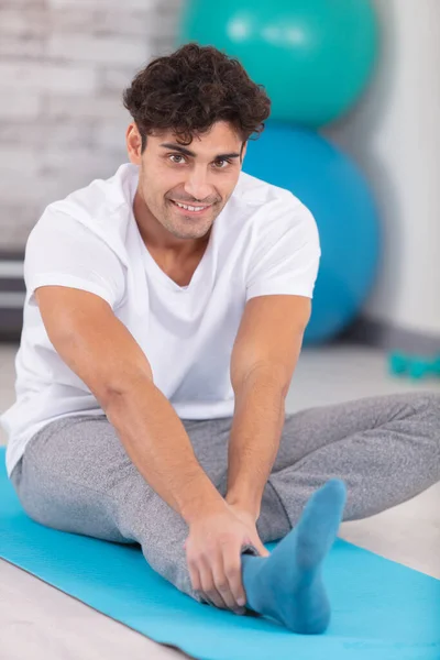 Handsome Young Man Doing Hamstring Stretch Exercise Stock Image