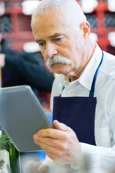 Starszy Sprzedawca Korzystający Tabletu Cyfrowego Sklepie Winami — Zdjęcie stockowe