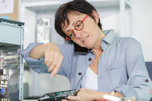 サービスセンターでパソコンの修理をしている女性は — ストック写真