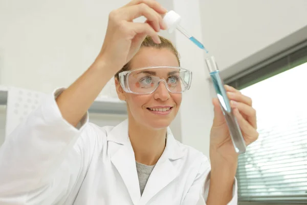 Kadın Test Tüpüne Bakarken Gülümsüyor — Stok fotoğraf
