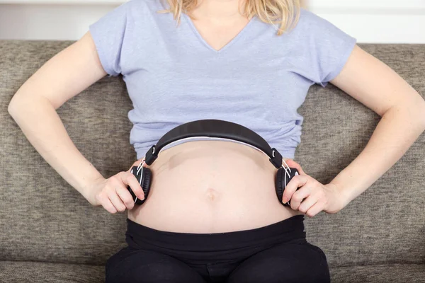 배꼽에 헤드폰으로 임신한 여자의 — 스톡 사진