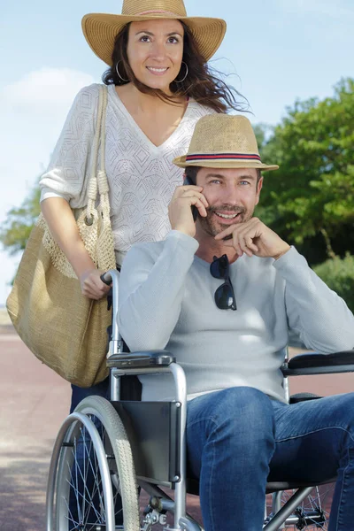 Pár Ven Procházku Muže Invalidním Vozíku Pomocí Telefonu — Stock fotografie