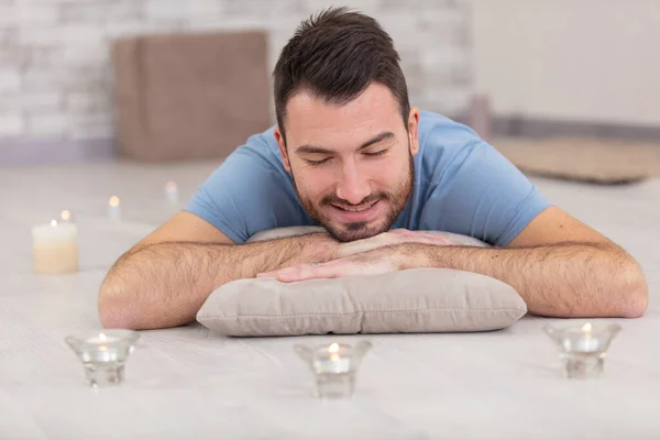 Man Lays Floor Surrounded Candles — Stock Photo, Image