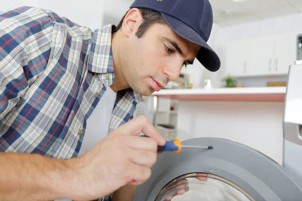 Homem Está Consertando Uma Máquina Lavar Roupa — Fotografia de Stock