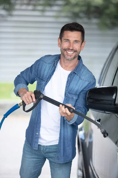 男子在洗他的车在自助服务汽车清洗站 — 图库照片