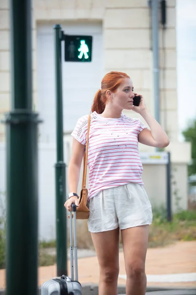 Kobieta Przechodząca Przez Ulicę Torbami Podróżnymi Telefonem Komórkowym — Zdjęcie stockowe