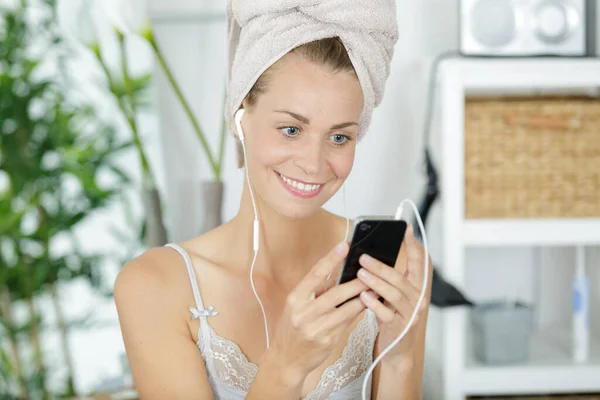 Kobieta Przygotowuje Się Nosić Słuchawki Podłączone Smartfona — Zdjęcie stockowe