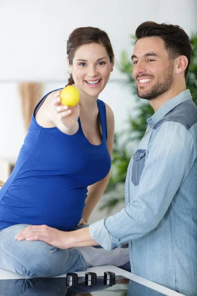 Leende Gravid Kvinna Med Make Visar Citron — Stockfoto