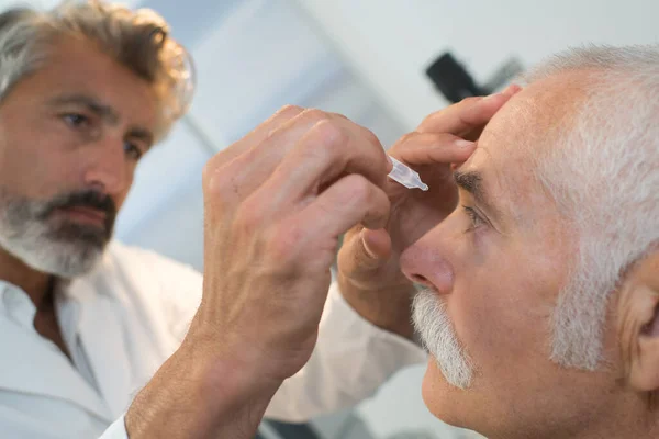 Lekarz Wkładając Krople Oczu Starszym Mężczyznom — Zdjęcie stockowe