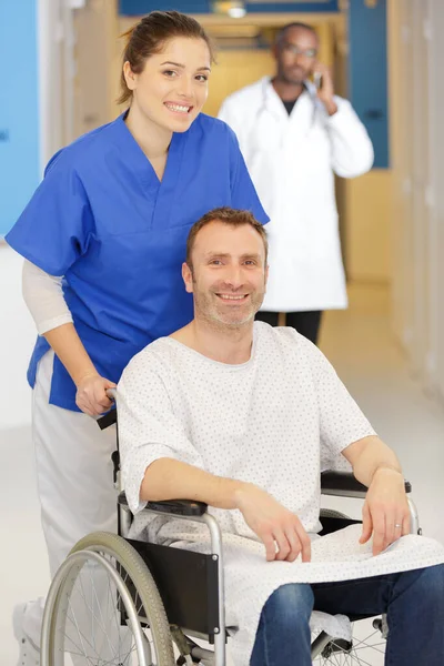 坐轮椅的男人和住院的护士 — 图库照片