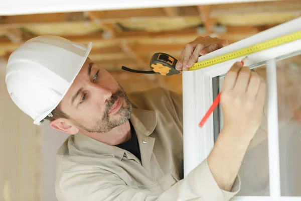 Männlicher Bauarbeiter Misst Ein Fenster — Stockfoto