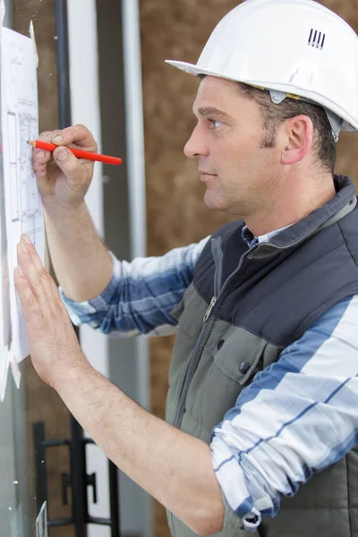 Trabajador Tomando Notas Sobre Los Planes Construcción — Foto de Stock