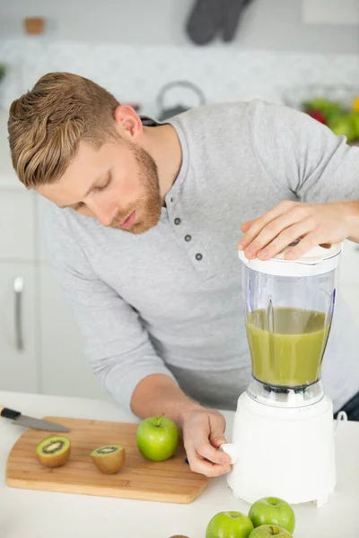 男运动员在厨房里制作果汁或者甜点 — 图库照片