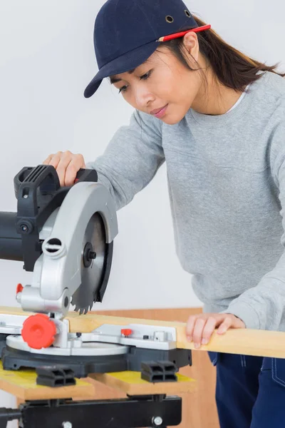 職人の女性使用丸鋸木材を切断 — ストック写真