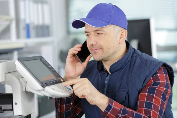Middelbare Leeftijd Man Aan Telefoon Repareren Van Een Printer — Stockfoto
