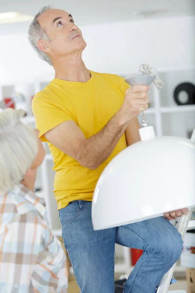Senior Male Doing Home Repair Lamp — Stock Photo, Image