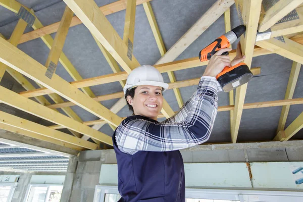 木造の屋根の上で働く若い女性建築家は — ストック写真