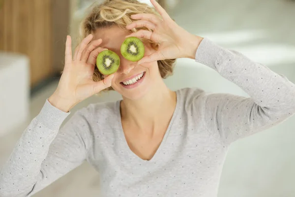 Mujer Cubriendo Sus Ojos Con Rodajas Kiwi — Foto de Stock