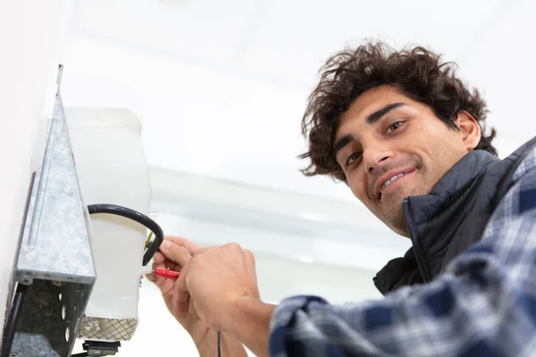 Glimlachende Knappe Elektricien Repareert Elektrische Doos — Stockfoto