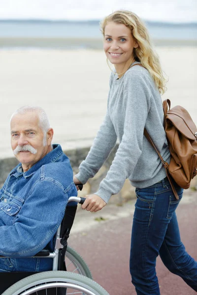 Dospělá Dcera Tlačí Svého Staršího Otce Jeho Invalidním Vozíku — Stock fotografie