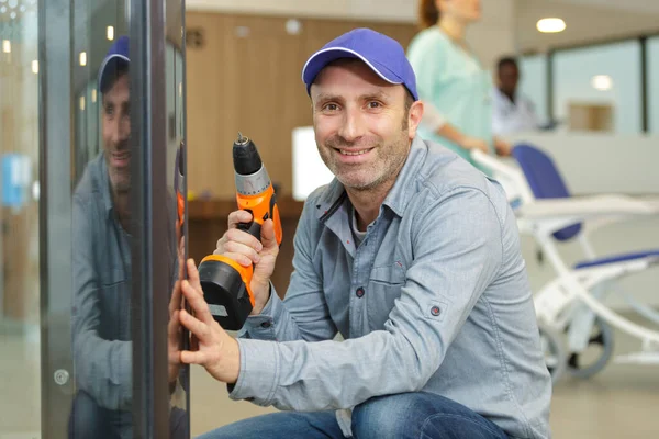 Arbeiter Bei Wartungsarbeiten Krankenhaus Mit Akkubohrmaschine — Stockfoto
