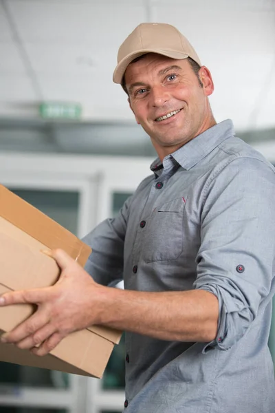 Entrega Homem Sorrindo Segurando Uma Caixa Papelão — Fotografia de Stock